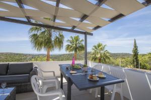 a patio with a blue table and white chairs at Villa Angel by Algarve Holidays in Loulé