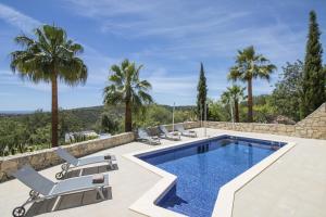 a villa with a swimming pool and palm trees at Villa Angel by Algarve Holidays in Loulé