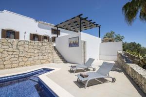 a patio with two chairs and a swimming pool at Villa Angel by Algarve Holidays in Loulé