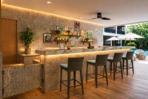 a bar in a restaurant with stools at Kata Beach Pool View Condo - 400m from the Beach in Kata Beach