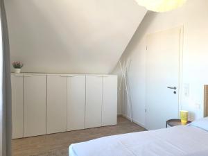 a bedroom with white cabinets and a bed at Heiligenhafenbude 2 in Heiligenhafen