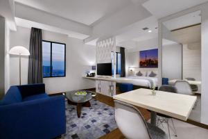 a hotel room with a king bed and a living room at StarRay Hotel Jakarta Kebayoran in Jakarta