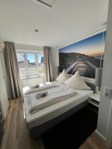 a bedroom with two beds and a large window at Strandhotel Sylt Wenningstedt in Wenningstedt