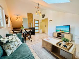 a living room with a couch and a tv at Cocon Savoyard - Vues Alpes - 2 king size - Rando & VTT - Parking in Albertville