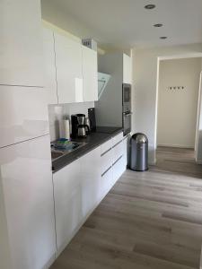 a kitchen with white cabinets and a counter top at Seaside-Amrum-6 in Norddorf