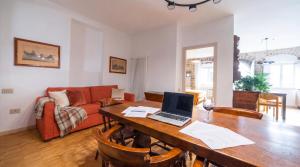 a living room with a table with a laptop on it at Roberto Historic House in Gubbio