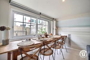 a dining room with a table and chairs and a window at Le clos du figuier in Arzon +23 photos