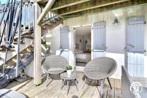 a patio with three chairs and a table at Le clos du figuier in Arzon