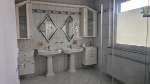 a bathroom with two sinks and a mirror at Pension Highway - Löhne Löhner Straße 111 in Löhne +13 photos
