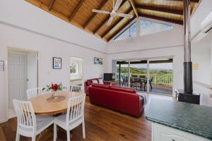 a living room with a table and a red couch at Surfside Ocean Beach Denmark Holiday Accommodation in Denmark