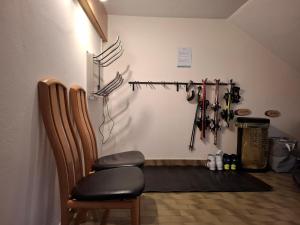 a room with two chairs and a wall with baseball bats at FEWO Erika in Presseggen