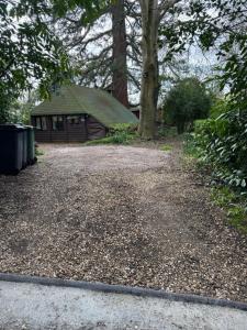 a gravel driveway in front of a house at Woodland Chalet at Otters Green in Botley