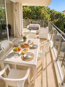 ein Tisch und Stühle auf einem Balkon mit Essen darauf in der Unterkunft Mare Incanto - Agenzia Cocal in Caorle