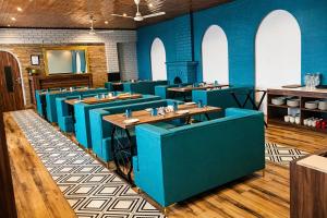 a restaurant with blue walls and wooden tables at Teesta Hotels, Kalimpong in Kalimpong