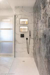 a bathroom with white walls and a stone wall at L'Attrape-Rêves in La Gaude +33 photos