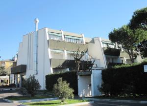 a white building with bushes in front of it at CORALLO 31 con Piscina in Lido delle Nazioni +6 photos