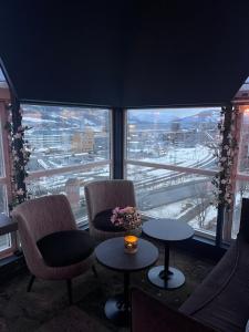 a room with two chairs and tables and a large window at Aksjemøllen - by Classic Norway Hotels in Lillehammer