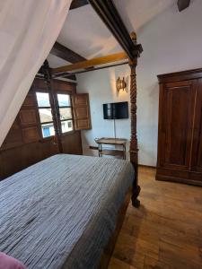 a bedroom with a bed and a tv on the wall at Las Casas de Isu in Villaviciosa