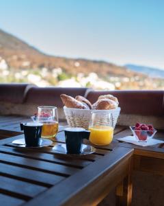a table with two glasses of orange juice and baskets of bread at L'Attrape-Rêves in La Gaude