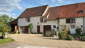 a white house with brown roofs and a driveway at Logis côté Cour in Varennes-lès-Narcy +10 photos