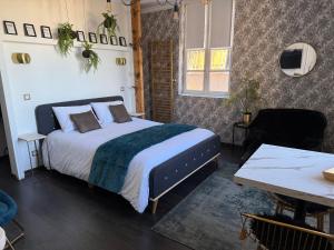 a bedroom with a bed and a table at La Loge 45 in Rodez