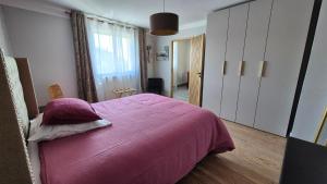 a bedroom with a bed with a pink blanket at Maison canal - Douceur Occitane in Moissac