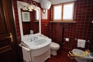 a red tiled bathroom with a sink and a toilet at Suite 21 - Residence Contini in Falconara Marittima +14 photos