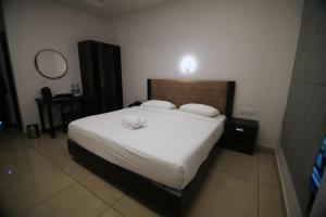 a bedroom with a large white bed and a mirror at Travlounge Adimali in Chillithodu