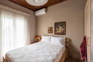a bedroom with a large bed and a window at Olympus & Sea Harmony in Katerini