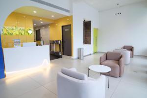 a lobby with couches and a table and chairs at Travlounge Adimali in Chillithodu