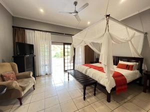 a bedroom with a canopy bed and a couch at Abangane Guest Lodge in Hazyview +36 photos