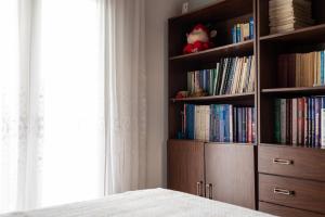 a book shelf filled with books next to a bed at Olympus & Sea Harmony in Katerini