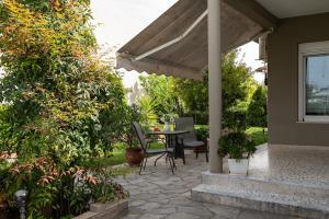 a patio with a table and chairs under an umbrella at Olympus & Sea Harmony in Katerini