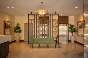 a lobby with a green couch and a chandelier at Courtyard by Marriott Guadalajara Andares in Zapopan