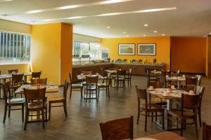 a restaurant with tables and chairs and a bar at Courtyard by Marriott Guadalajara Andares in Zapopan