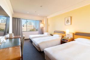 a hotel room with two beds and a window at Hotel New Otani Saga in Saga