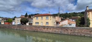 a building next to a river next to buildings at Maison canal - Douceur Occitane in Moissac