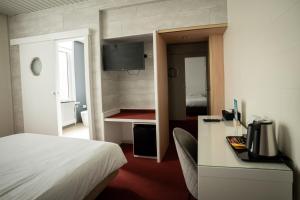 a hotel room with a bed and a desk and a bedroom at Hotel Richmond in Blankenberge