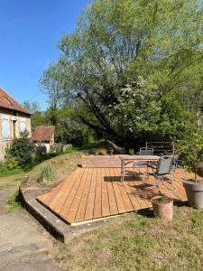 a wooden deck with a picnic table and two chairs at Moulin de Saint-Civran in Saint-Civran