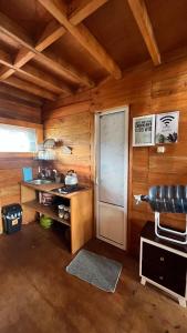 a kitchen with a door in a wooden cabin at Cabin Dieng Db in Diyeng +16 photos