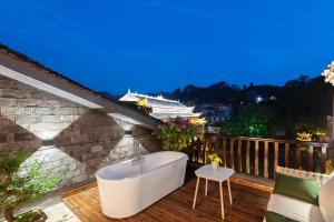 a bath tub on a deck with a cruise ship at Phoenix River View Hotel-Free pick up service from Railway in Fenghuang County