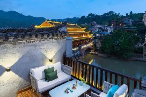 a balcony with a view of a river at Phoenix River View Hotel-Free pick up service from Railway in Fenghuang County