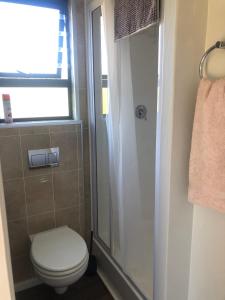 a bathroom with a toilet and a shower at Plett Pods - Casetta del Fuoco - Eco Container Cottage in Plettenberg Bay +21 photos