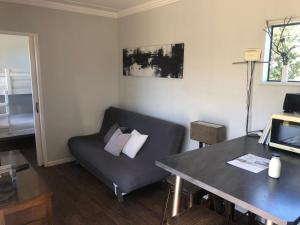 a living room with a couch and a table at Plett Pods - Casetta del Fuoco - Eco Container Cottage in Plettenberg Bay