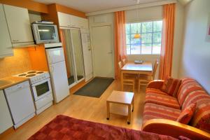a living room with a couch and a kitchen at Tahko Huoneistohotelli A in Tahkovuori