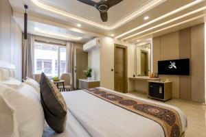 a hotel room with a large bed and a television at Holiday Homez, City Centre with Free Airport & Train Station Pickup in New Delhi