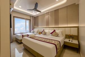 a hotel room with two beds and a window at Holiday Homez, City Centre with Free Airport & Train Station Pickup in New Delhi