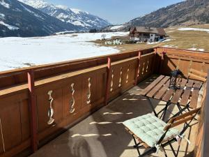 a balcony with a bench and a snow covered mountain at a feines Platzl in Asch