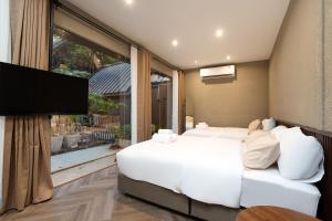 a bedroom with two beds and a flat screen tv at OHASIS by OH Hotels in Bangkok