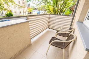 a chair sitting on a balcony with a window at Héthajnal Apartman in Debrecen